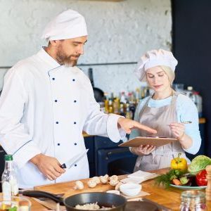 Immagine che mostra una giovane ragazza mentre aiuta uno chef. È usata come immagine del corso gratuito "AIUTO CUOCO" del progetto GOL